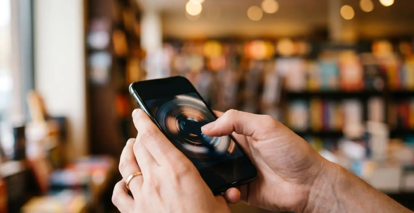 Hand hält ein Smartphone, auf dem eine interaktive 360-Grad-Produktvisualisierung eines Schuhs zu sehen ist.