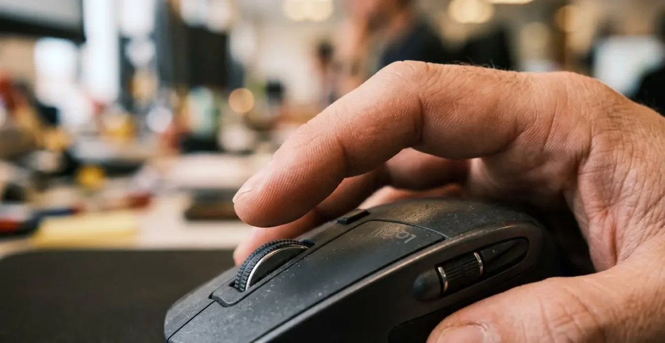 Makroaufnahme einer Hand auf Computermaus zeigt Moment der Entscheidung